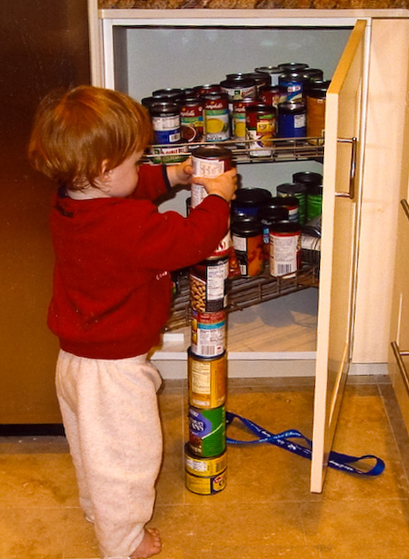 a baby stacking cans up